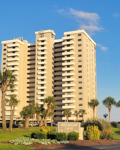 Beach house with wraparound balconies seen from the sand at golden hour