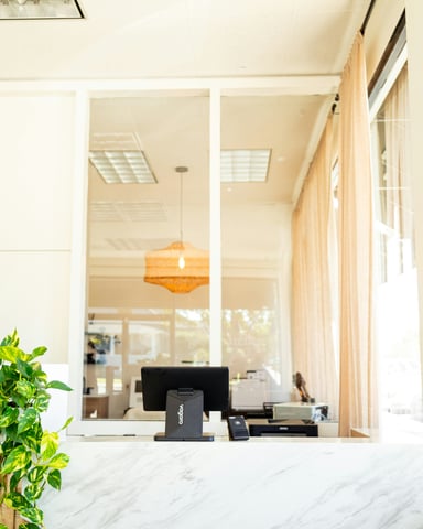 Bright airy reception desk with marble counter and natural light