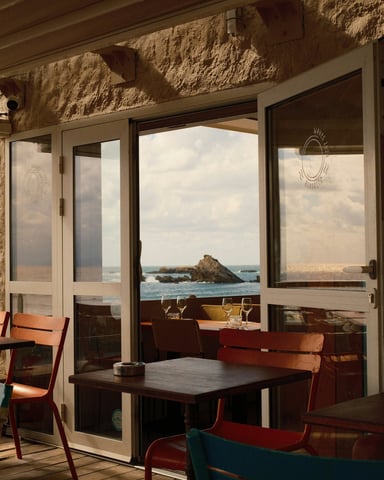 Beachside bar interior with ocean view through large windows