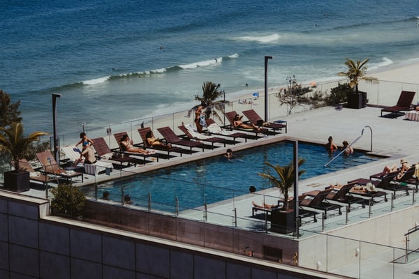 Rooftop pool with lounge chairs overlooking the ocean and beach