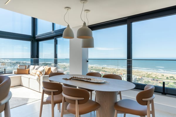 Bright dining room with floor-to-ceiling windows overlooking the ocean
