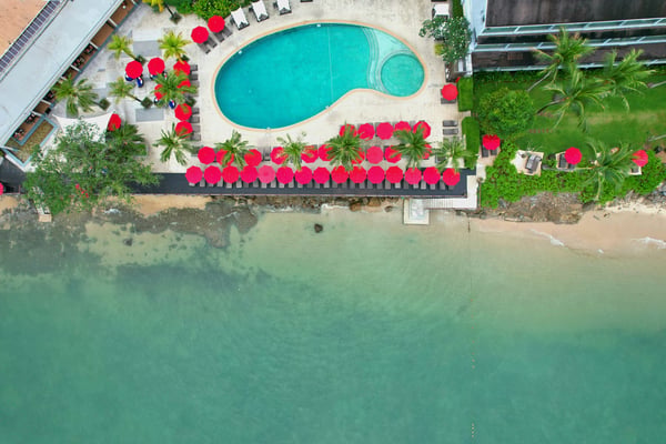 Aerial view of a resort pool and beach chairs right on the ocean